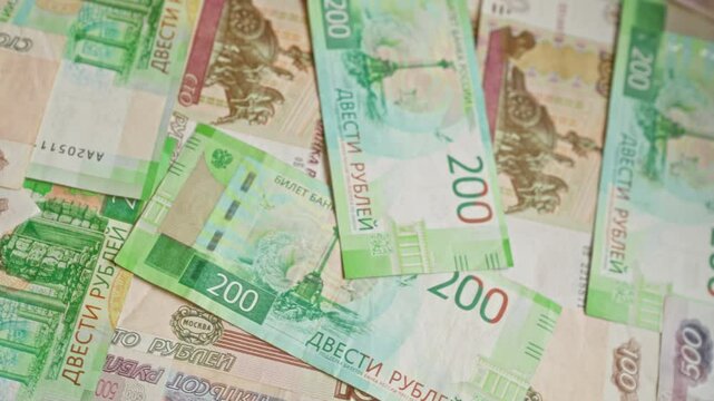 Russian ruble banknotes scattered in a random pattern showing different denominations and colorful designs under soft lighting
