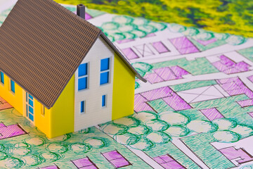 Real Estate concept with home model on imaginary cadastral map o