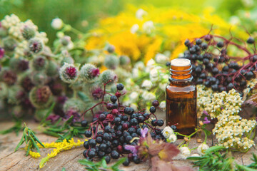 Flower and herbal extract in a bottle. Selective focus.
