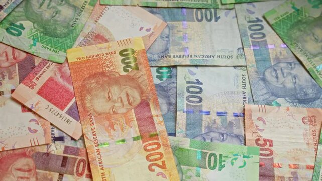 South african rands banknotes featuring nelson mandela lay spread out in various denominations, highlighting the colorful currency of south africa.