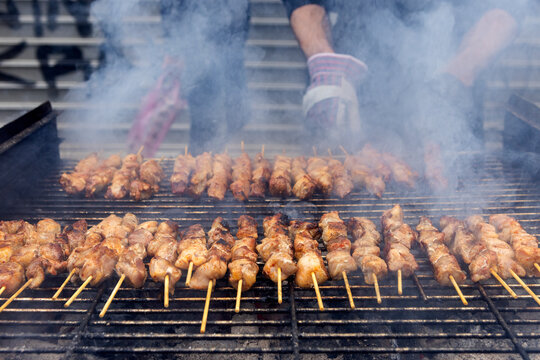 A grill filled with skewers of meat cooking