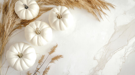 Four white pumpkins and pampas grass are arranged on a white marble surface. Thanksgiving day
