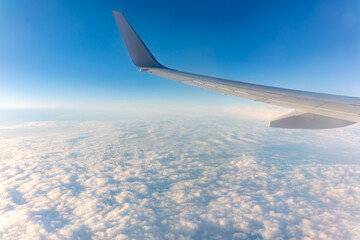 Beautiful salmon dawn and the wing of an airplane above the clouds.