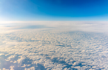View from the airplane window at a beautiful cloudy sky and the airplane wing