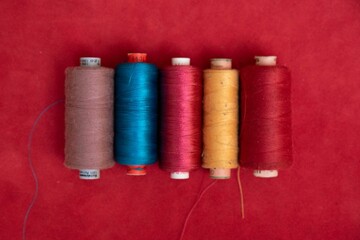 Vibrant colored threads on red background