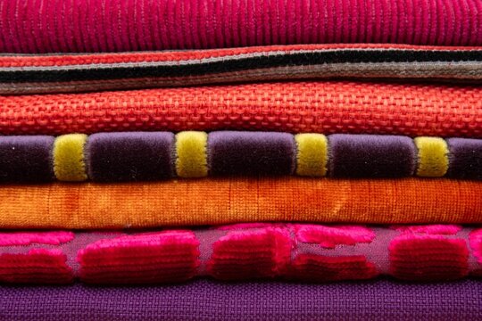 Colorful stacked textiles with vibrant textures.