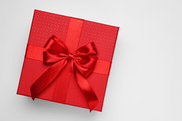 Gift box with bow on light grey background, top view. Space for text