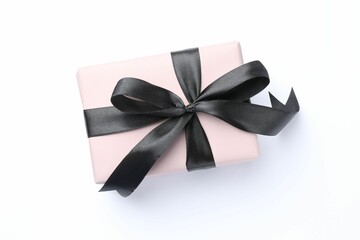 Beautiful gift box with black bow isolated on white, top view