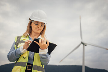 A skilled female engineer inspects a wind turbine with her tablet, ensuring efficiency and optimal performance, contributing significantly to sustainability and renewable energy initiatives