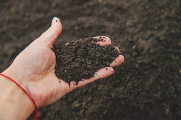 Man holding soil in his hands. Selective focus.