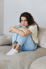 Fototapeta premium Sad woman sitting at the sofa with depression