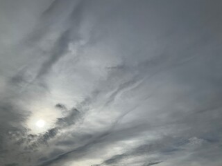 Fototapeta premium Cloudy sky with grey clouds and sun - natural background. Topics: weather, meteorology, atmosphere, air space, season