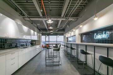 A spacious office room with high tables and chairs for a snack and relaxation.
