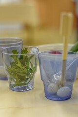 Water in a glass with a straw and vegetables on the table.