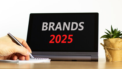 Planning brands 2025 new year symbol. Concept words Brands 2025 on beautiful black tablet. Beautiful white background. Businessman hand. Business brands 2025 new year concept. Copy space.