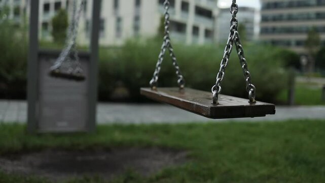 Empty playground after rain. Swing got wet in raindrops. Summer or spring rainy day. No people. No children. High quality FullHD footage