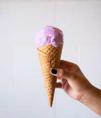 Purple ice cream cone on white textured background