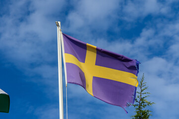 Swedish flag with vibrant colors waving against a clear blue sky in a serene outdoor setting