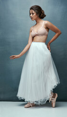 Girl, ballerina or dancing in studio with dress, confidence or elegant motion isolated on blue background. Artist, ballet dancer or woman with passion for contemporary style or talent in audition