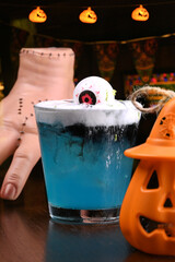 drink blue curacao cocktail with decorative eye and ginger spuma at halloween party