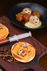 halloween idea funny and horrifying dishes two mini pizza with skull and mushroom with sauce in a syringe dumpling ghost meat