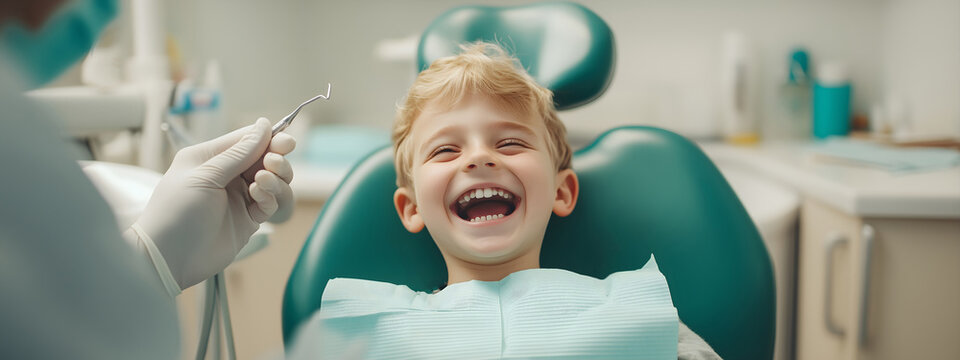 Young smiling boy being prepared for regular dental check-up. sitting at dental chair, open mouth during oral check up while doctor. Visiting dentist office. Medicine and stomatology concept