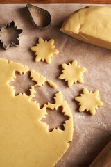 Star shapes cut out from rolled out dough to prepare traditional Linzer Christmas cookies
