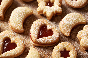 Traditonal Linzer Christmas cookies filled with strawberry marmalade and dusted with sugar - closeup of heart shape