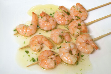 Garlic prawn skewer with olive oil on white background