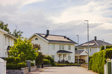 Modern villas with solar panels on roofs in suburban residential area on summer day. Sweden.