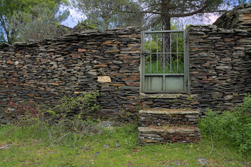 Wall made of slate stone with a metallic fence