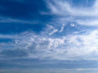 A serene view of the sky filled with soft white clouds against a vibrant blue backdrop, perfect for conveying tranquility and nature's beauty.