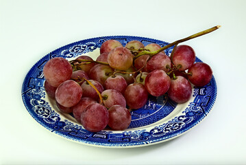 Czerwone winogrona na starym talerzu