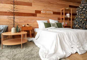 Interior of cozy bedroom with Christmas tree and presents