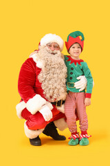 Santa Claus and cute little elf on yellow background