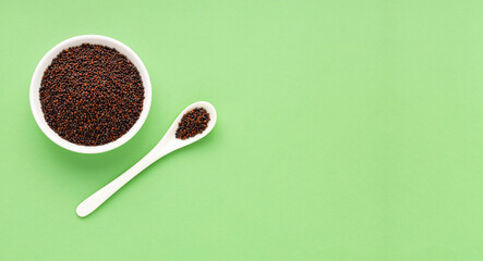 Brassica juncea - Dried organic brown mustard seeds in bowl and spoon.