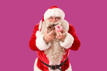 Santa Claus eating tasty donuts on purple background