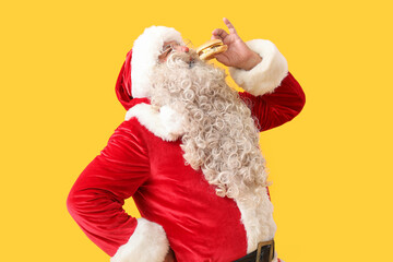 Santa Claus eating tasty burger on yellow background