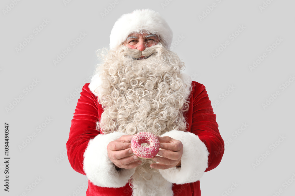 Sticker Santa Claus with tasty donut on white background