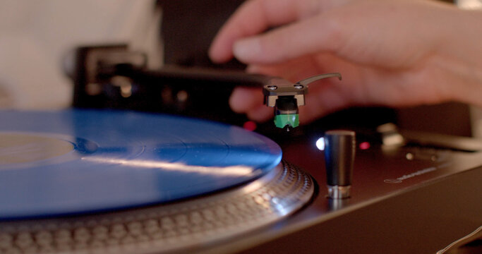 A person is enthusiastically playing a record on a classic turntable, enjoying the nostalgic sounds it produces