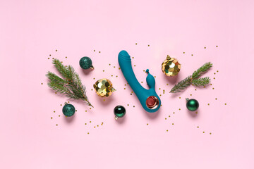 Composition with vibrator, Christmas decorations and fir branches on pink background