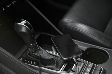 Mobile phone with charging cable in car, closeup