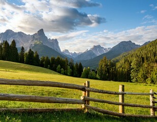 a lush green meadow bordered by a rustic wooden fence leading to a forest with mountain views