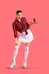 Young pin-up waitress in roller skates with soda on red background
