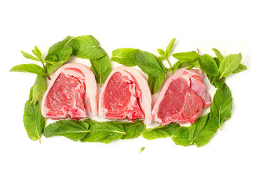 Fresh uncooked lamb loin chops and mint leaf on white background. High quality meat product cut by butcher in perfect size for cooking. Food supply chain and agriculture industry.