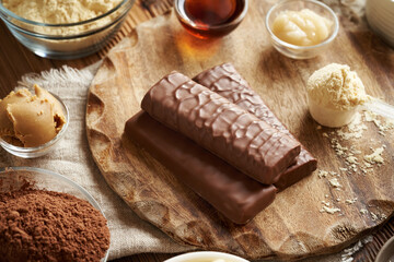 Protein chocolate bars with ingredients - whey protein powder, peanut butter, raw cacao, honey and maple syrup