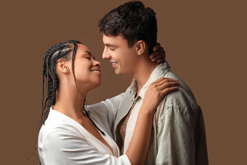 Young couple kissing on brown background