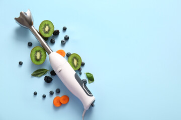 Modern blender with fruits and berries on blue background
