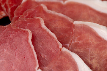 sliced ham with bacon on a board