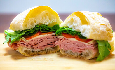 Italian mortadella bologna sandwich with arugula, tomato and cheese on ciabatta bread